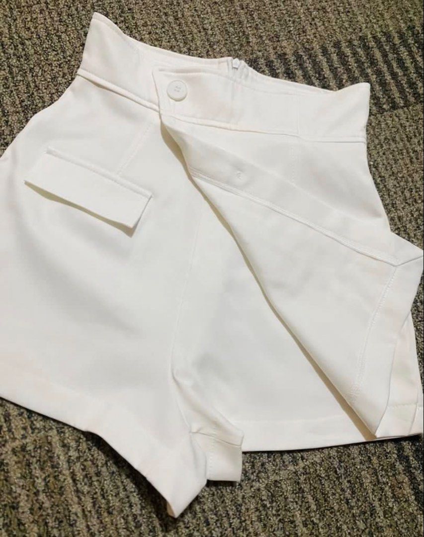 White High-Waisted Skorts with Button Details (Category: Skirts) located in Marikina City. Submitted by jessylady10 (Listing ID 1468981483, Image 2). Description: - Color: White - Style: High-waisted skorts with asymmetric front flap - Comfort: Built-in shorts underneath for worry-free movement - Details: Decorative front buttons and small structured side pocket - Closure: Clean back with hidden top-center zipper - Fabric: Smooth with minimal str