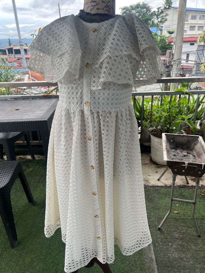 White lace ruffle midi dress with buttons (Category: Dresses) located in Caloocan City. Submitted by thewardrobe05 (Listing ID 1467376239, Image 2). Description: - Color: White - Material: Patterned lace fabric - Design: Round neckline with full front button closure - Sleeves: Short layered ruffle sleeves - Fit: Fitted waist with a flared midi skirt - Versatility: Ideal for daytime events, dates, or weekend brunches; easy to pair with flats or sa