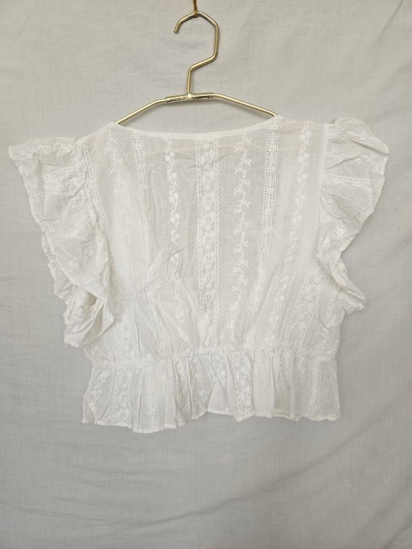 White lace short sleeve blouse crop top (Category: Blouses) located in Quezon City. Submitted by _pcloset (Listing ID 1469005352, Image 2). Description: - Color: White - Style: Short sleeve top with square neckline - Details: Floral lace panels on front and back - Finish: Ruffled hemline and cuffs - Fabric: Lightweight.