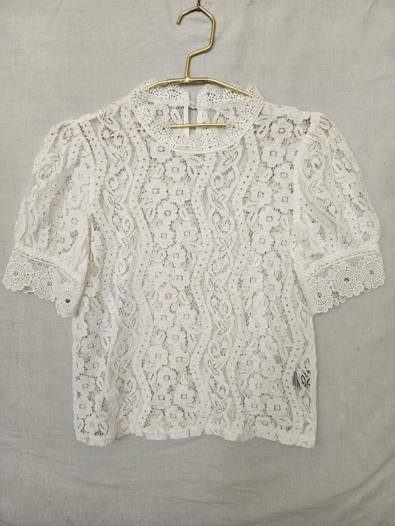 White lace short sleeve floral patterned blouse (Category: Blouses) located in Quezon City. Submitted by _pcloset (Listing ID 1469005339, Image 1). Description: - Color: White - Material: Light and breathable fabric - Design: All-over woven floral pattern with short sleeves - Details: Scalloped hem on collar and sleeves, back button loop closure - Styling: Perfect to pair with skirts or high-waisted denim for casual outings.