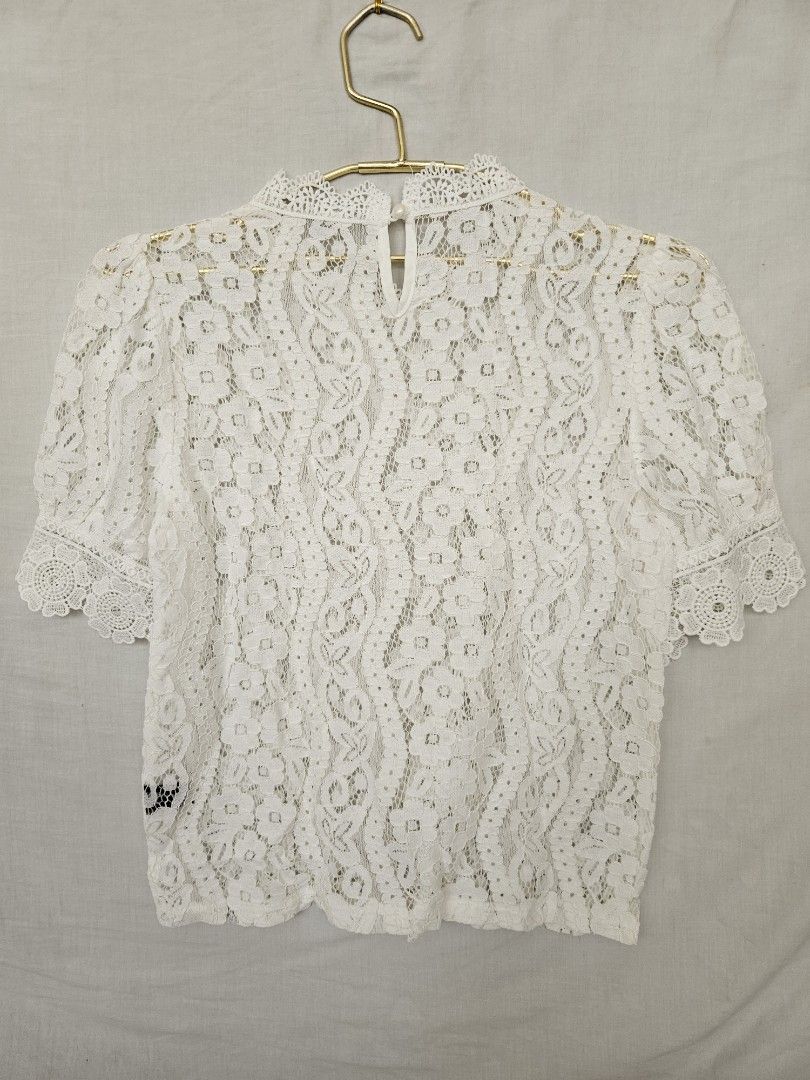 White lace short sleeve floral patterned blouse (Category: Blouses) located in Quezon City. Submitted by _pcloset (Listing ID 1469005339, Image 2). Description: - Color: White - Material: Light and breathable fabric - Design: All-over woven floral pattern with short sleeves - Details: Scalloped hem on collar and sleeves, back button loop closure - Styling: Perfect to pair with skirts or high-waisted denim for casual outings.