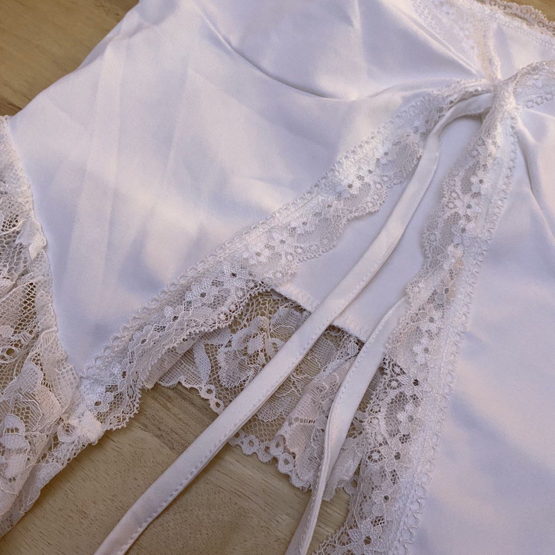 White Lace Trim Tie Front Crop Top (Category: Sleeveless) located in Cavite. Submitted by helloize (Listing ID 1466630976, Image 2). Description: White sleeveless crop top with delicate lace trim along the square neckline and hem. Features a tie-front closure with a dainty ribbon. Soft fabric, great for layering or wearing on its own during warm weather. Clean condition, no flaws noticed. Super nice fabric.