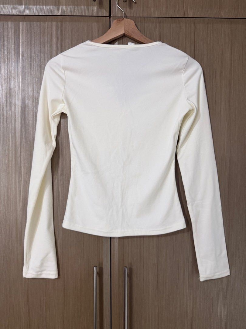 White long sleeve top with lace V-neck (Category: Longsleeves) located in Taguig. Submitted by mengxir20193848 (Listing ID 1469001005, Image 3). Description: - Color: White - Style: Fitted long-sleeve top with clean back design - Neckline: V-neck accented with delicate lace trim - Fabric: Soft, highly stretchable material for all-day comfort - Versatility: Perfect basic piece for daily wear, easily paired with high-waisted jeans or skirts.