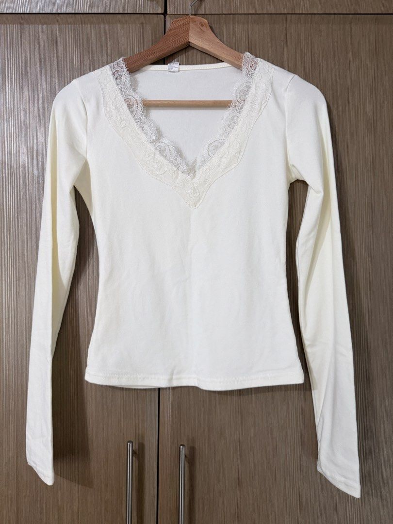 White long sleeve top with lace V-neck (Category: Longsleeves) located in Taguig. Submitted by mengxir20193848 (Listing ID 1469001005, Image 2). Description: - Color: White - Style: Fitted long-sleeve top with clean back design - Neckline: V-neck accented with delicate lace trim - Fabric: Soft, highly stretchable material for all-day comfort - Versatility: Perfect basic piece for daily wear, easily paired with high-waisted jeans or skirts.