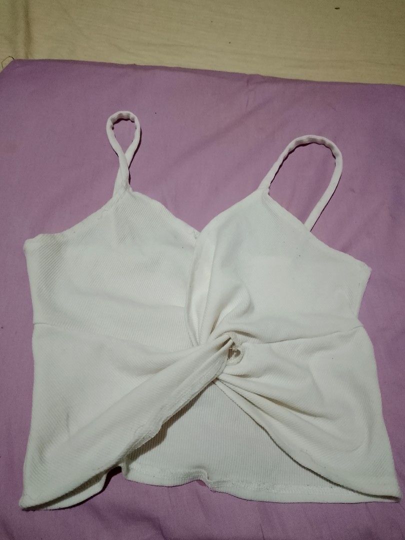 White ribbed cami top with front twist detail (Category: Sleeveless) located in Batangas. Submitted by sheenx.09 (Listing ID 1468974698, Image 1). Description: - Color: White - M on tag (xs to s) - Style: Cropped ribbed camisole with thin shoulder straps and front twist knot detail ♥️ - Fabric: Soft, high-stretch material for maximum comfort 🫶 - Fit: Flattering cropped length - Versatility: Perfect for warm weather, layering, or pairing with hig