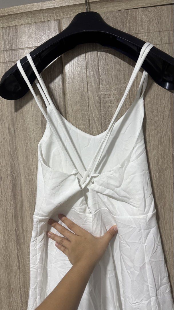 White Spaghetti Strap Long Dress (Category: Dresses) located in Davao. Submitted by wisedeer-bcd8 (Listing ID 1469083517, Image 3). Description: Plain white long dress with thin double straps. Cross-back strap detail. V-neckline in front and back. Fitted waist with a flared skirt falling down to midi or maxi length. Fabric looks lightweight and smooth. Simple, clean look for casual days or outdoor events. Just needs a quick iron to smooth out the