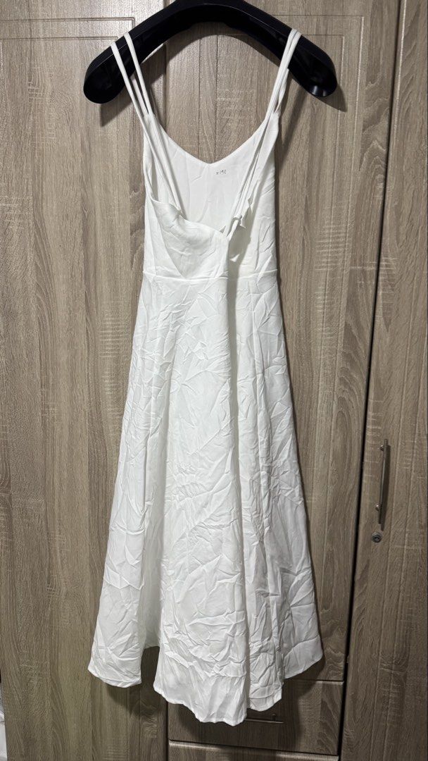 White Spaghetti Strap Long Dress (Category: Dresses) located in Davao. Submitted by wisedeer-bcd8 (Listing ID 1469083517, Image 2). Description: Plain white long dress with thin double straps. Cross-back strap detail. V-neckline in front and back. Fitted waist with a flared skirt falling down to midi or maxi length. Fabric looks lightweight and smooth. Simple, clean look for casual days or outdoor events. Just needs a quick iron to smooth out the
