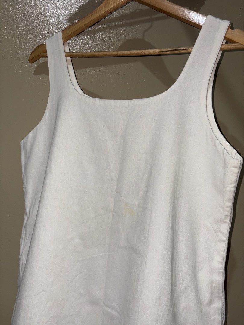White Square Neck Tank Top (Category: Sleeveless) located in Caloocan City. Submitted by stella_mari27 (Listing ID 1469105170, Image 2). Description: - Color: Plain white - Style: Square neckline, thick straps, straight hem - Material: Sturdy, great for layering or hot days - Flaw: Small yellowish stain near the front center (needs a proper wash).