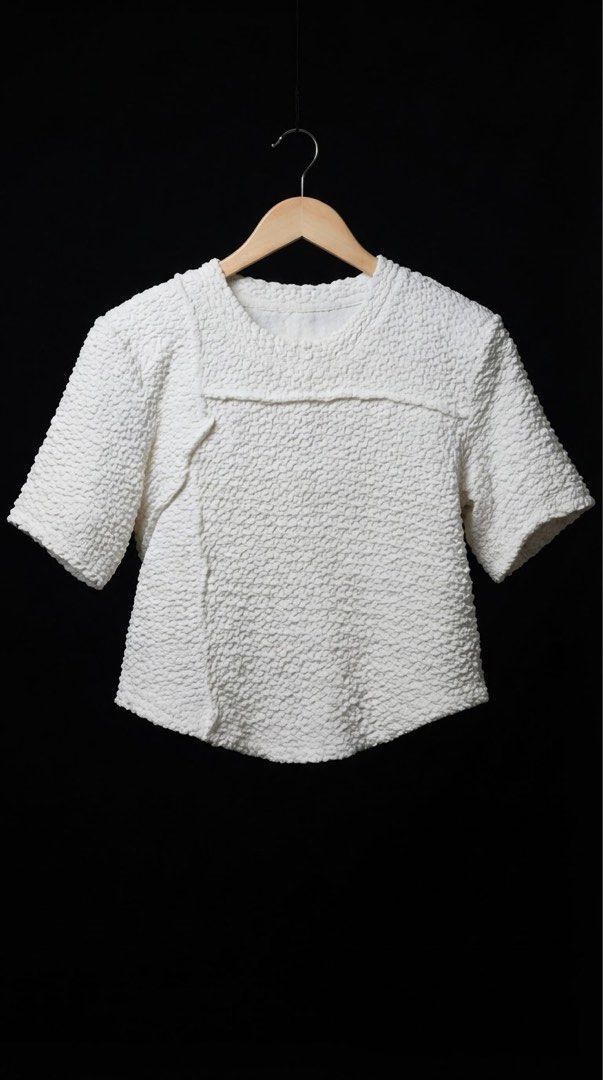 White textured short sleeve blouse with asymmetrical front seam (Category: Blouses) located in Cavite. Submitted by grandearth.39df3f (Listing ID 1468955830, Image 1). Description: - Color: Crisp white - Fabric: Soft, stretchy, all-over textured bubbly material - Fit: Structured boxy fit with a round neckline - Design: Unique asymmetrical seam on the right front and slightly curved center hem - Versatility: Super comfortable for daily wear, easil