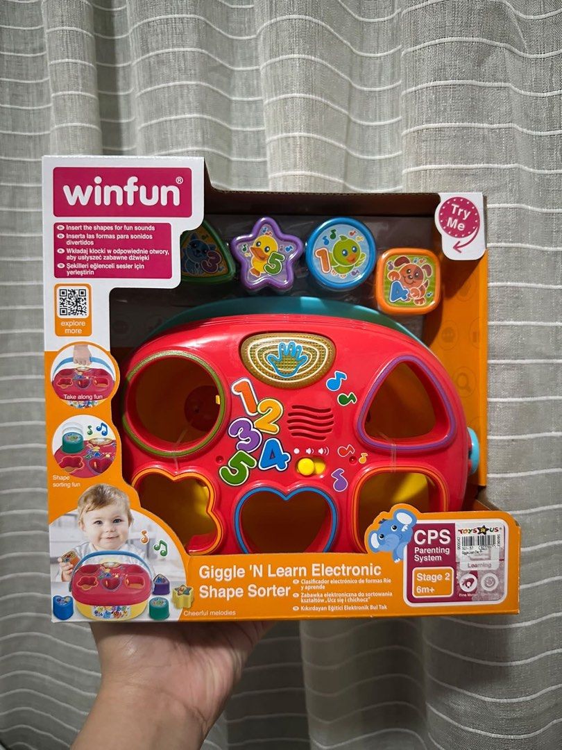 Winfun Giggle 'N Learn Electronic Shape Sorter toy (Category: Educational & Learning Toys) located in Manila. Submitted by bei10 (Listing ID 1469004935, Image 1). Description: - Winfun Giggle 'N Learn Electronic Shape Sorter - Ideal for toddlers 6 months and up - Includes vibrant shapes (star, triangle, cylinder, cube) and red sorting base - Plays cheerful melodies and sounds upon correct placement - Promotes early learning, numbers, and hand-eye