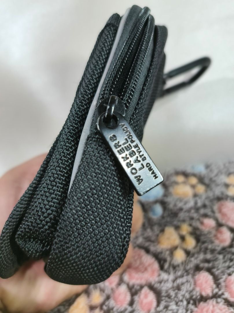 Workers Label Hip Transporter Case Pouch Black (Category: Belt bags, Clutches and Pouches) located in San Leonardo. Submitted by burgossanleonardo.12345 (Listing ID 1469070156, Image 3). Description: - Color: Black - Material: Tough, durable nylon with sturdy zippers - Storage: Front zipper pocket and main compartment with inner card pocket - Portability: Includes a back belt loop and carabiner clip for easy attachment - Use: Compact utility pouc