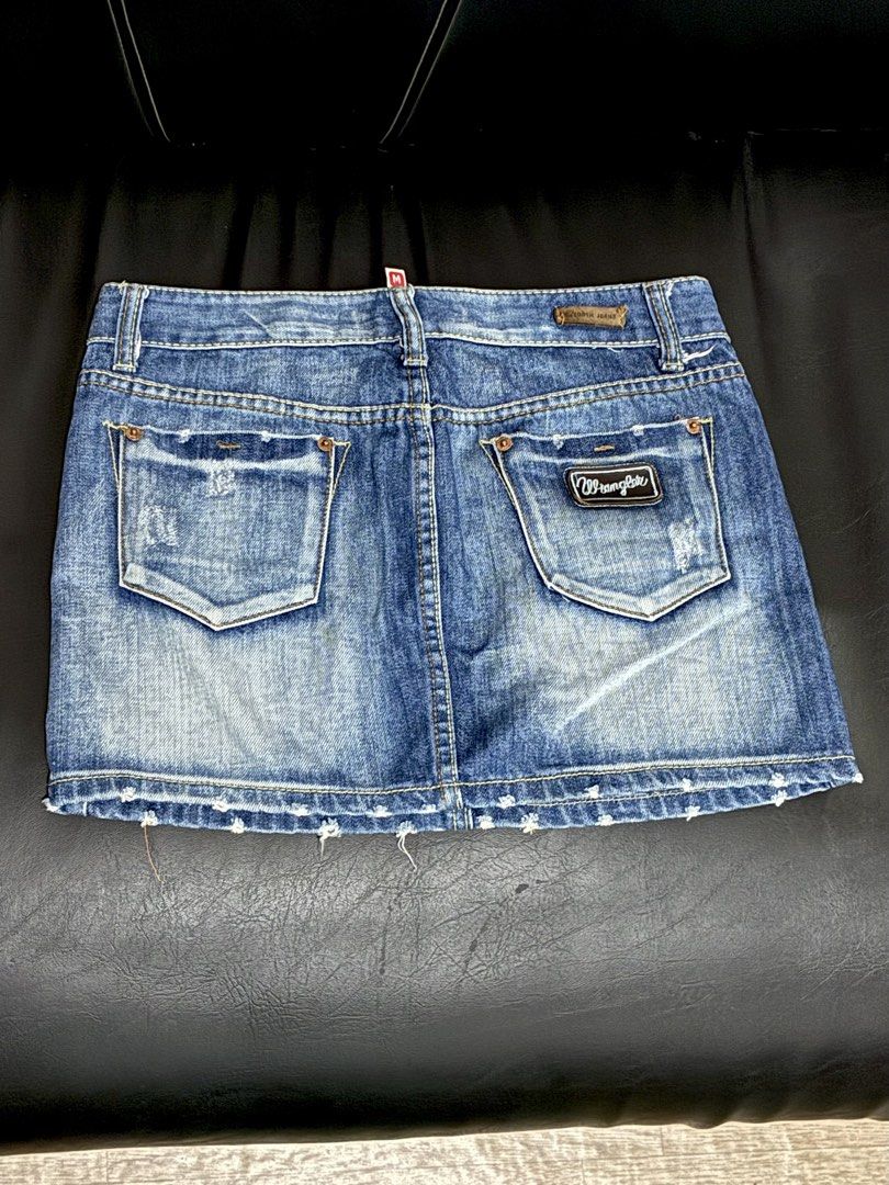 Wrangler Mini Skirt Blue Distressed Size M (Category: Skirts) located in Tanauan. Submitted by theitgirlsdibs4 (Listing ID 1469156643, Image 2). Description: - Brand: Wrangler - Size: Medium (tag attached) - Wash: Medium blue with cool Y2K distressed details and frayed hem - Style: Classic five-pocket design with contrast yellow stitching - Details: Branded metal hardware and signature back pocket patch - Condition: Brand new with tags, great for