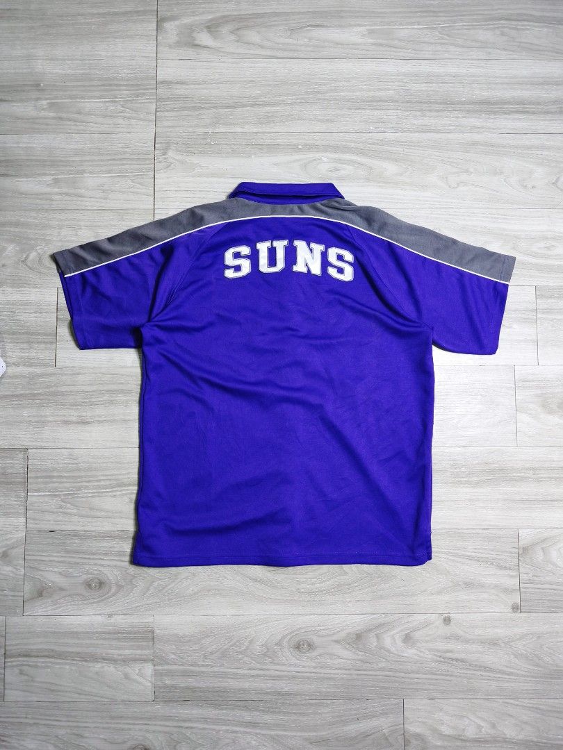 Y2k NBA Phoenix Suns warmer jersey button down polo (Category: Tshirts & Polo Shirts ) located in Paranaque City. Submitted by pickersform (Listing ID 1469021207, Image 2). Description: - Y2k NBA Phoenix Suns warmer jersey button down polo - Size:XLyouth fits Medium-Large dimes 23x29 - Details: Embroidered Suns logo on chest, large embroidered SUNS lettering on the back - Condition: Clean fabric with bright, vibrant colors.