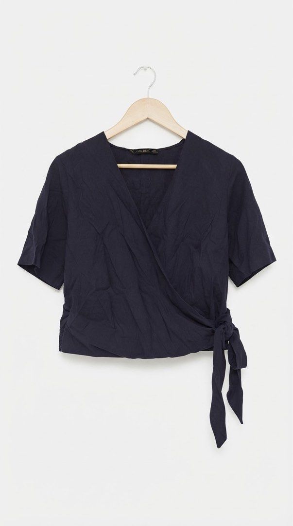 Zara Navy Blue Wrap Tie Short Sleeve Blouse (Category: Blouses) located in Cavite. Submitted by grandearth.39df3f (Listing ID 1468955332, Image 1). Description: - Brand: Zara - Color: Navy blue - Style: Wrap blouse with V-neckline and short sleeves - Closure: Secure side tie with fabric bow - Fabric: Lightweight and breathable - Versatility: Great for casual everyday wear or easy layering - Small on Tag but fit till Med. .