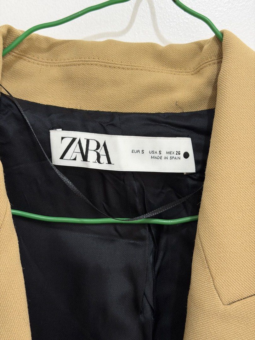 ZARA Oversized Camel Blazer (Category: Coats, Jackets and Outerwear) located in Malolos. Submitted by eadiana (Listing ID 1468969228, Image 3). Description: - Brand: Zara - Size: S - Origin: Made in Spain -Color: Light Caramel - Design: Classic lapel collar, single button closure, and structured shoulders - Details: Front flap pockets, black inner lining, four buttons on each cuff, and single back vent - Condition: Clean finish, ready to wear.