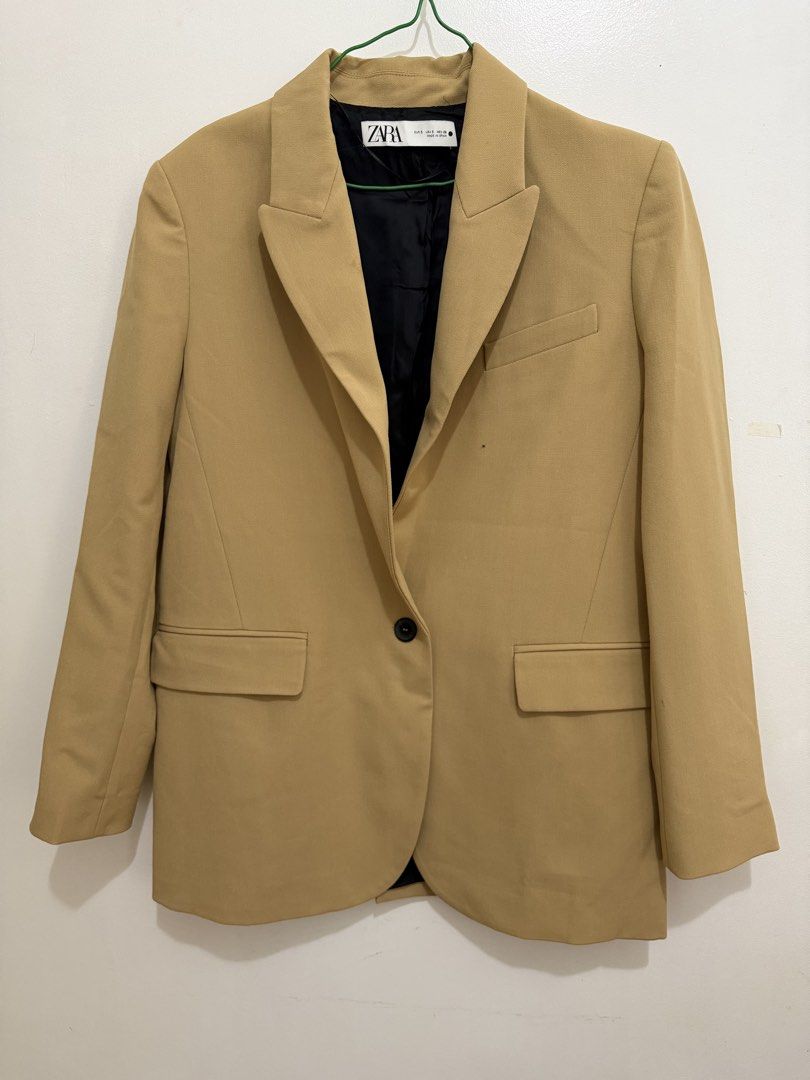 ZARA Oversized Camel Blazer (Category: Coats, Jackets and Outerwear) located in Malolos. Submitted by eadiana (Listing ID 1468969228, Image 1). Description: - Brand: Zara - Size: S - Origin: Made in Spain -Color: Light Caramel - Design: Classic lapel collar, single button closure, and structured shoulders - Details: Front flap pockets, black inner lining, four buttons on each cuff, and single back vent - Condition: Clean finish, ready to wear.