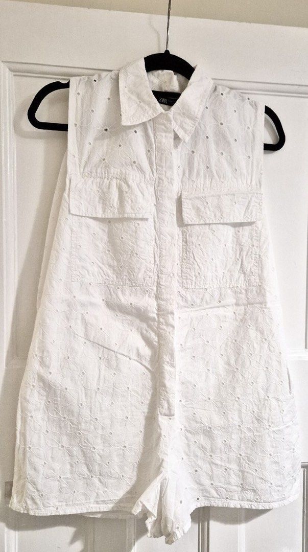 ZARA White Eyelet Sleeveless Romper (Category: Rompers) located in Tabaco. Submitted by camila_dp (Listing ID 1469160855, Image 1). Description: ZARA White Eyelet Sleeveless Romper - Brand: Zara - Style: Sleeveless button-down romper with collar - Detail: All-over floral eyelet embroidery and dual chest pockets - Fabric: Lightweight and breathable - Size: XS but can fit Xs to Small.