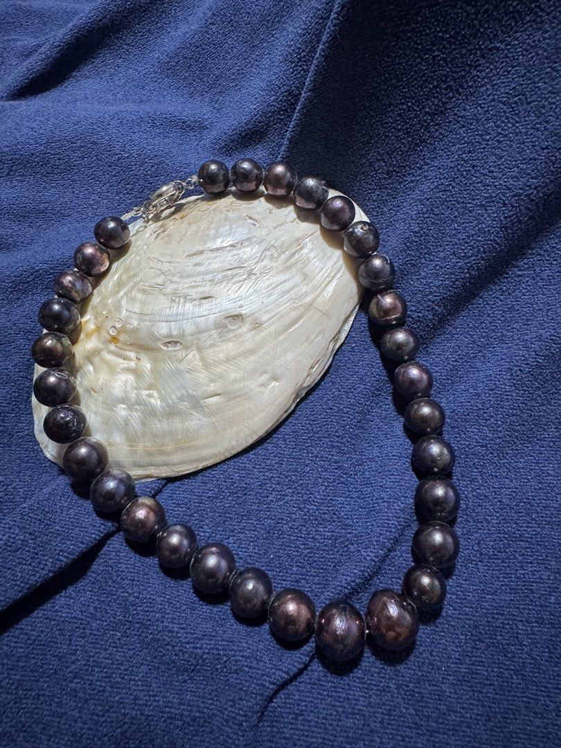 11 mm to 15mm (Category: Necklaces) located in Angeles City. Submitted by zyeplustradings (Listing ID 1465471940, Image 2). Description: • single-strand necklace of near-round to slightly baroque cultured pearls • Features dark, metallic overtones with rich bronze, purple, and green reflections • Finished with a polished silver-tone or white metal clasp The surface has a high-gloss, mirror-like luster that reflects light sharply. A few subtle gro