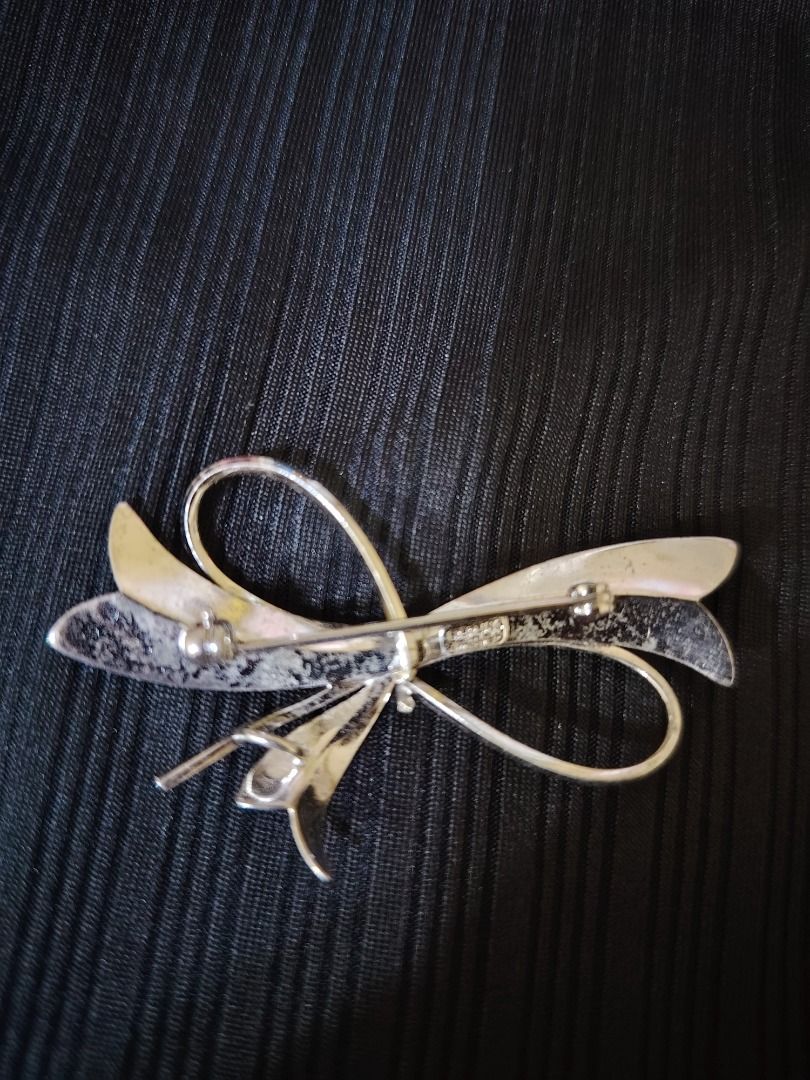 925 pure sterling silver bow brooch pen (Category: Brooches) located in Caloocan City. Submitted by izy2cananua_2 (Listing ID 1465480925, Image 2). Description: - Style: Vintage costume jewelry silver-toned ribbon bow brooch - Finish: Textured brushed finish on the looped ends - Closure: Secure pin clasp on the reverse side - Condition: Good vintage condition with light signs of wear on the back.