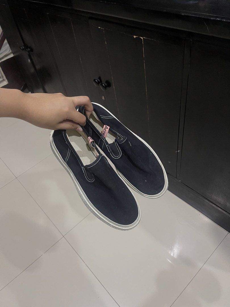 ACNE STUDIOS Canvas Slip-On Sneakers (Black / Off-White) (Category: Sneakers) located in Cagayan de Oro. Submitted by kmcurations (Listing ID 1465493875, Image 1). Description: ACNE STUDIOS Canvas Slip-On Sneakers (Black / Off-White) Brand: Acne Studios Features: - Low-top slip-on silhouette made from durable black canvas with white contrast stitching. - Signature pale pink Acne Studios logo ribbon tag along the outer collar. - Textured off-white