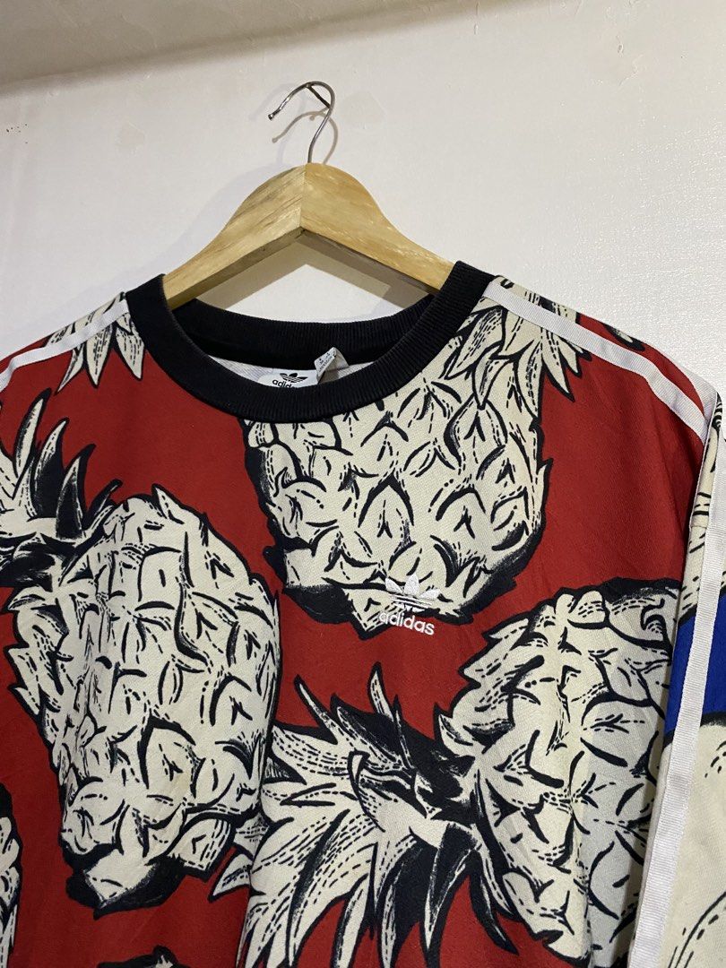 Adidas Pineapple Print BF Sweater Red Black (Category: Coats, Jackets and Outerwear) located in Cebu City. Submitted by arsenyong (Listing ID 1465518653, Image 3). Description: - Brand: Adidas 23 by 26 Excellent Need wash only - Design: Bold all-over pineapple print with vibrant red backdrop and blue/white accents - Style: Classic crewneck sweatshirt with black ribbed cuffs and collar - Logo: Official Adidas trefoil logo on the chest - Material: 