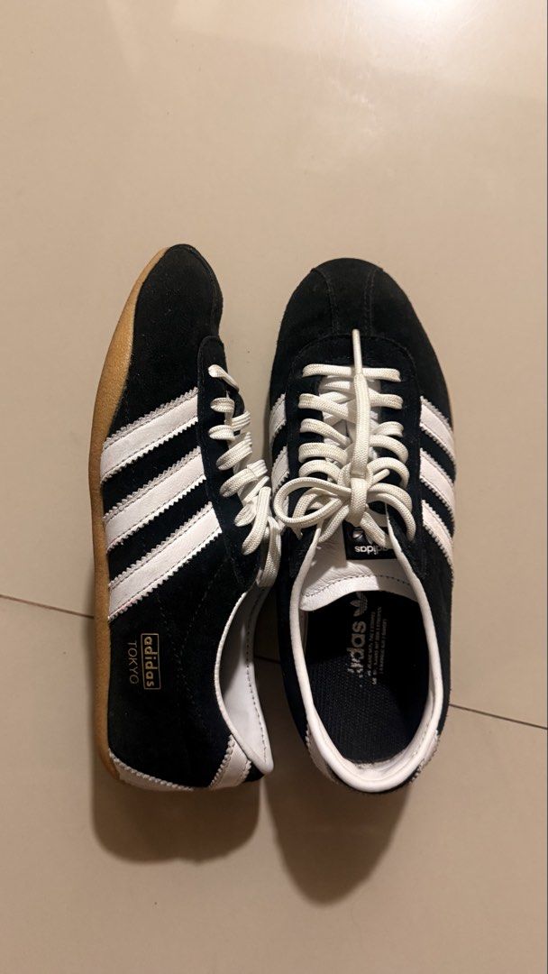 Adidas Tokyo Black White Sneakers (Category: Sneakers) located in Quezon City. Submitted by bea3s (Listing ID 1465486894, Image 1). Description: - Brand/Model: Adidas Classic Black Suede Sneakers - Details: White stripes, white laces, and iconic gold Tokyo lettering on the side - Sole: Durable gum rubber sole with minimal wear - Interior: White leather collar with Adidas trefoil logo on the tongue and insole - Condition: Clean overall, well-maint