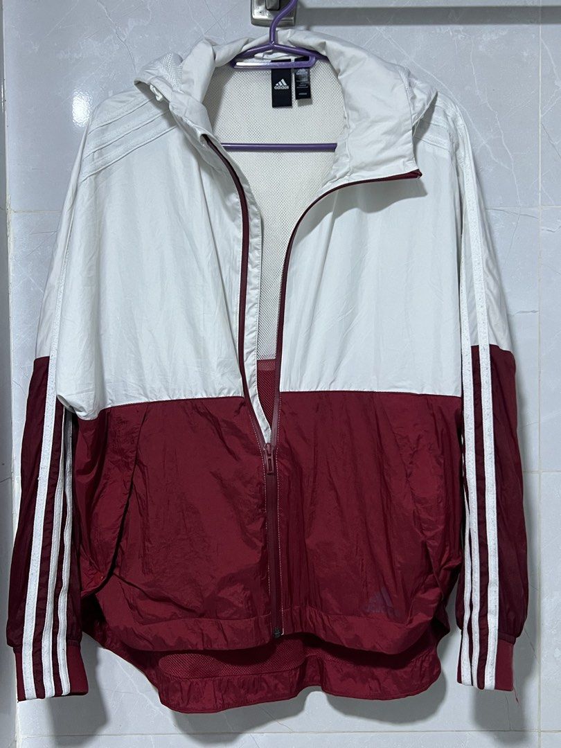 Adidas White and Maroon Windbreaker Jacket (Category: Coats, Jackets and Outerwear) located in Manila. Submitted by jj0451315 (Listing ID 1465492773, Image 1). Description: - Brand: Adidas - Style: Zip-up windbreaker with hood - Color: White on top, maroon on bottom with classic white three stripes on sleeves - Size: Small (S) - Lining: Breathable inner mesh lining - Features: Adjustable hood drawstrings - Ideal for: Workouts, casual wear, and br
