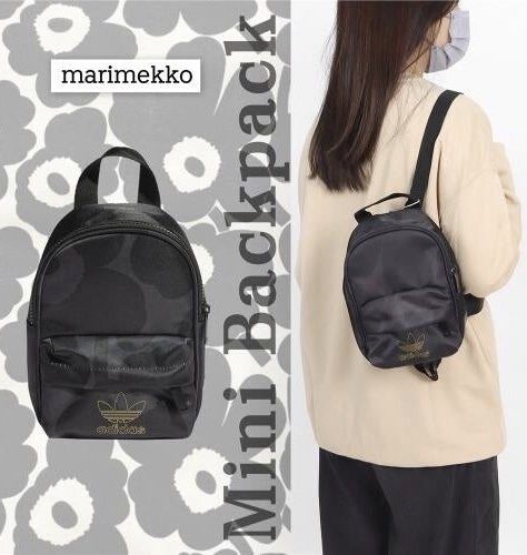 Adidas x Marimekko Mini Backpack Black Gold (Category: Backpacks) located in Pasig City. Submitted by nakamuraka (Listing ID 1465397739, Image 1). Description: Adidas and Marimekko collaboration mini backpack. Black colorway featuring the iconic poppy print pattern throughout. Gold foil trefoil logo on the front pocket and branding tag on the side. Front zippered pouch pocket, main zip compartment, and adjustable shoulder straps. Compact size, gr