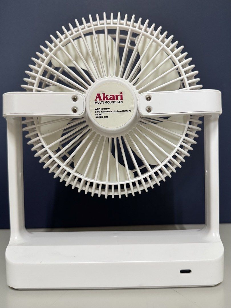 Akari Multi Mount Fan ARF-MF01W White (Category: Fans) located in Makati City. Submitted by avic_c (Listing ID 1465402998, Image 2). Description: - Brand: Akari Multi Mount Fan (Model: ARF-MF01W) - Condition: Working condition, well-maintained - Power: 3.7V 1200mAh lithium battery & 5V DC power with USB charging port - Design: Compact and portable in clean white - Versatile: Features a built-in wall mount bracket and hanging hook for easy placeme