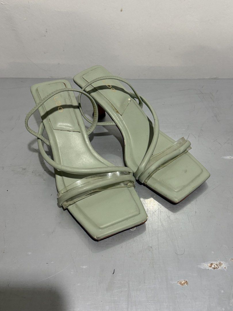 ALDO Sage Green Square Toe Heels Size 38 (Category: Heels) located in Santa Rosa. Submitted by leana_yna (Listing ID 1465486633, Image 1). Description: - Brand: ALDO - Style: Sage green mules with clear toe straps and square toe - Heel: Kitten heel - Size: US 7.5 / EUR 38 / UK 5 - Condition: Normal wear on soles; minor peeling and scuffing on the heel wrap as shown in photos.