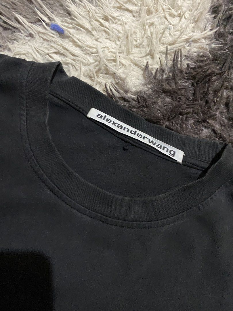 Alexander Wang black t-shirt size M (Category: Shirts) located in Caloocan City. Submitted by remythrift (Listing ID 1465416975, Image 3). Description: - Brand: Alexander Wang - Size: Medium (Regular fit) - Material: 100% Cotton (Made in Vietnam) - Design: Classic crewneck, short sleeves, subtle stacked logo print near the lower front hem - Condition: Shows gentle, even fading consistent with regular wear - Style: Versatile and easy to match with