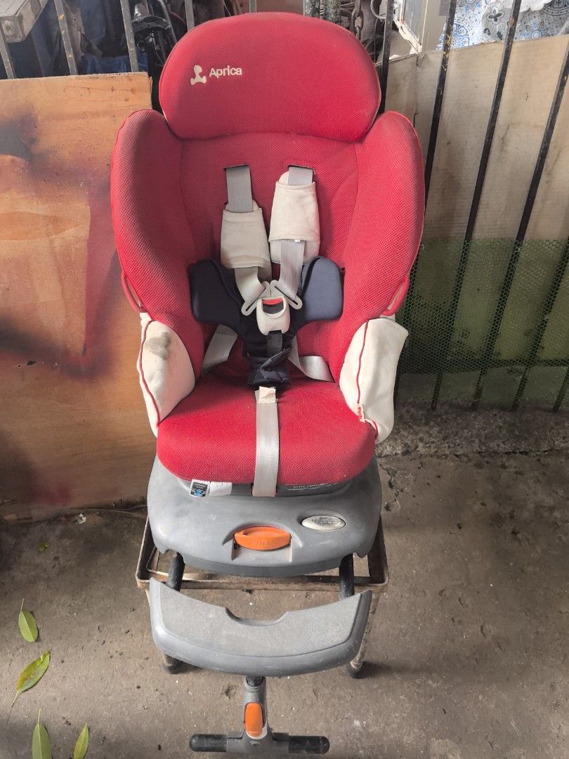 Aprica Car Seat with Support Stand (Category: Car Seats) located in Pasig City. Submitted by marielm.05 (Listing ID 1465542254, Image 2). Description: - Authentic Aprica car seat in a classic red and beige colorway - Includes complete harness straps, secure buckle system, head cushion insert, and base stand with adjustable leg support - Fully functional harness mechanism with a convenient central release button - Flaws: Fabric has noticeable dirt