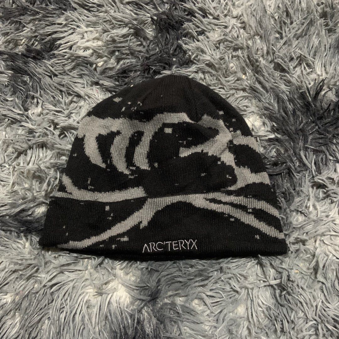 Arc'teryx Black Grey Graphic Knit Beanie (Category: Beanies) located in Compostela. Submitted by anyastark (Listing ID 1465391517, Image 2). Description: - Brand: Arc'teryx - Color: Black and grey - Design: All-over graphic pattern with embroidered lettering - Style: Ribbed cuff - Condition: Well-maintained, stored in a smoke-free home - Features: Warm and comfortable for cold weather - Cut tag.
