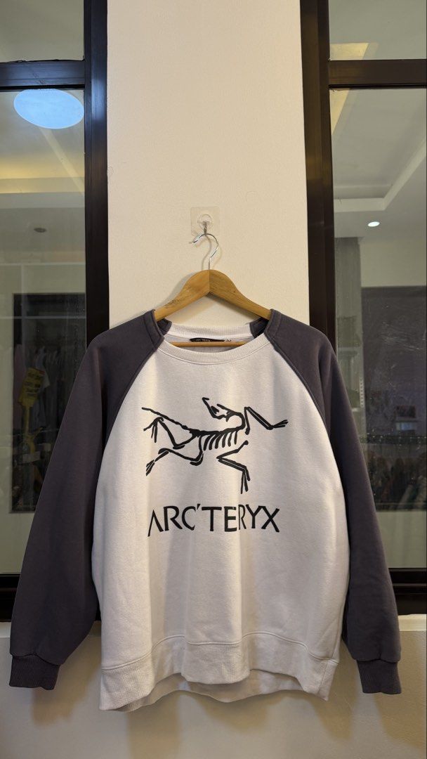 Arc'teryx Two-Tone Raglan Sweatshirt (Category: Coats, Jackets and Outerwear) located in Paranaque City. Submitted by mykapoynton (Listing ID 1465541331, Image 2). Description: Arc’teryx Two-Tone Raglan Sweatshirt - Style: Raglan sleeve sweatshirt with standard fit - Color: White body with dark grey sleeves - Design: Large skeletal graphic and brand text on front - Materials: 86% nylon, 14% elastane - Details: Ribbed crewneck, cuffs, and hem; mac