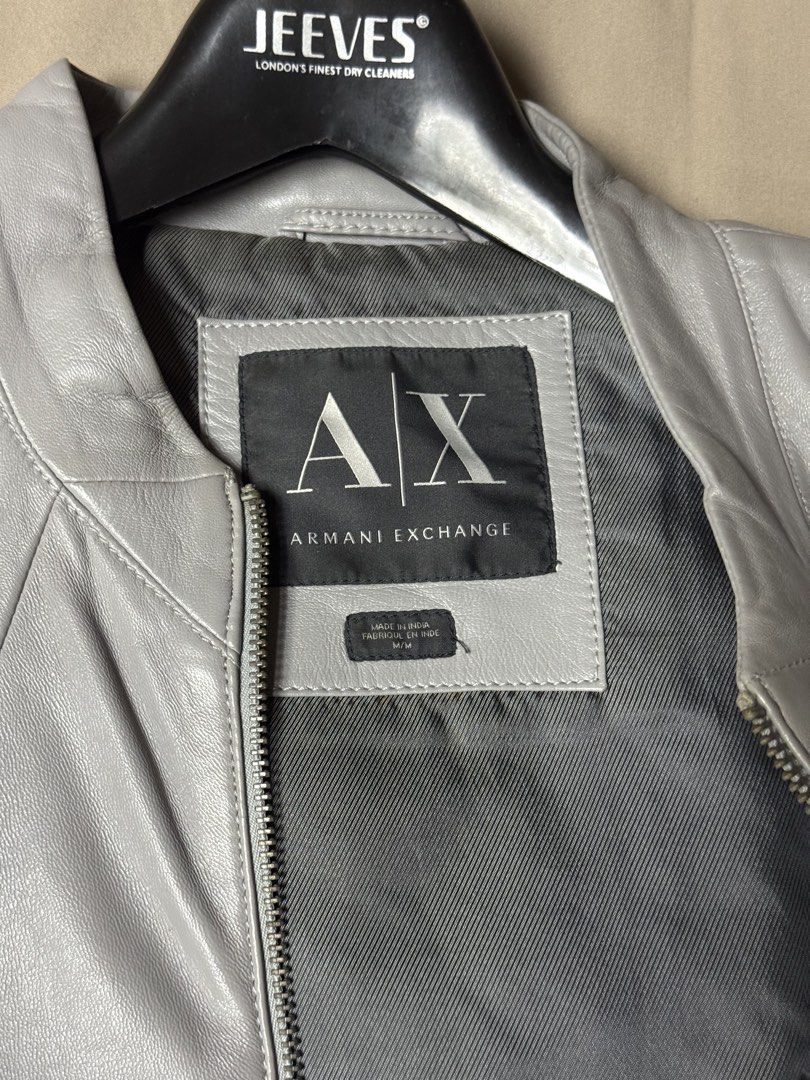 Armani Exchange Grey Leather Jacket Size M (Category: Coats, Jackets and Outerwear) located in Manila. Submitted by seangoart (Listing ID 1465507763, Image 2). Description: - Brand: Armani Exchange - Color: Grey - Size: M - Origin: Made in India - Material: Smooth leather with clean interior lining - Closure: Full front zip with branded hardware - Features: Zipped cuffs, vertical side pockets, and structured paneling.