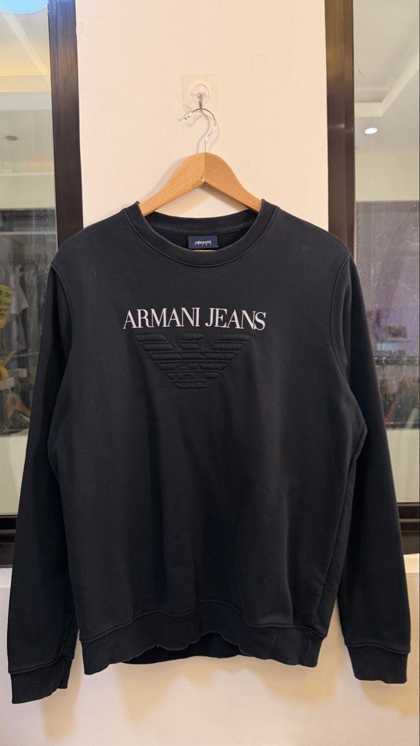 Armani Jeans Black Logo Sweatshirt Size M (Category: Tshirts & Polo Shirts ) located in Paranaque City. Submitted by preluxeshop_ph (Listing ID 1465558885, Image 2). Description: Armani Jeans Black Logo Sweatshirt Size M - Color: Solid Black - Size: Medium (M) - Material: 100% Cotton (Made in Thailand) - Design: Classic crewneck, long sleeves, large embroidered text and eagle logo on chest - Details: Ribbed collar, cuffs, and hem; plain back - Co