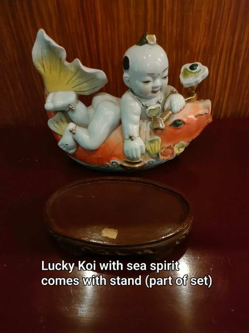 Asian Lucky Koi ceramic figurine set with boy (Category: Figurines & Statues) located in Caloocan City. Submitted by rise-edge (Listing ID 1465456961, Image 2). Description: - Stunning Asian Lucky Koi ceramic decor set - Includes a large piece with a resting boy on a koi, a tall leaping koi, and a small companion figurine - Features vibrant bright orange, white, and elegant gold accents - Mounted on a traditional dark wooden base - Ideal display 