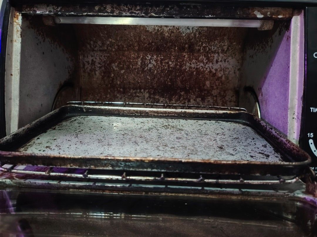 Astron Oven Toaster (Category: Ovens & Toasters) located in Mandaluyong City. Submitted by declutter_kween (Listing ID 1465526178, Image 3). Description: Astron oven toaster, model OT-774, capacity 7 liters. Black exterior housing with front control knobs and timer settings up to 15 minutes. Includes interior wire rack and baking tray. Interior walls show heavy use with baked-on grease and staining. Heating elements operational. Standard electric