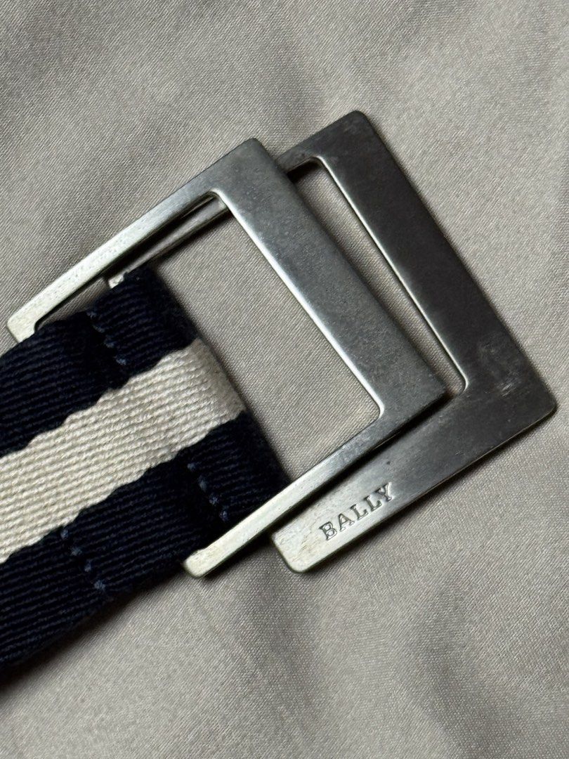 Authentic Bally Navy and White Canvas Webbing Belt (Category: Belts) located in Manila. Submitted by seangoart (Listing ID 1465529112, Image 1). Description: - Brand: Bally - Design: Navy and white striped canvas belt - Hardware: Silver-tone metal buckle with engraved Bally branding - Material: Sturdy and durable webbing strap - Fit: Fully adjustable - Condition: Clean fabric with minimal wear on hardware - Style: Classic casual, perfect for jean