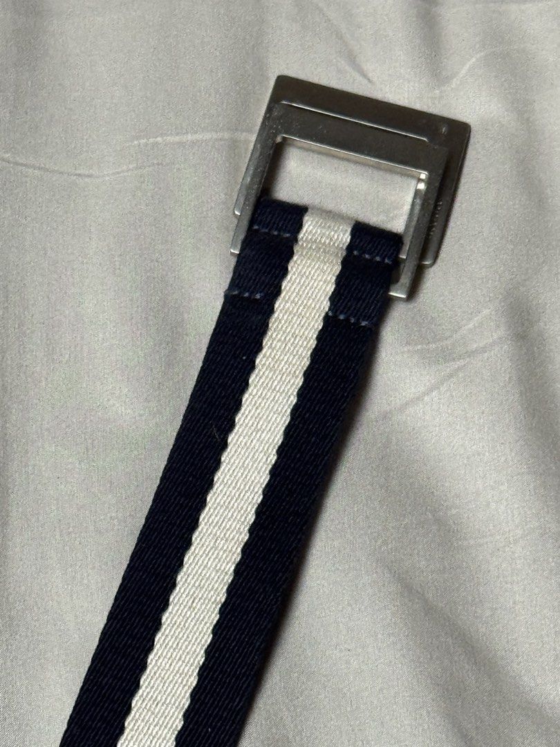 Authentic Bally Navy and White Canvas Webbing Belt (Category: Belts) located in Manila. Submitted by seangoart (Listing ID 1465529112, Image 2). Description: - Brand: Bally - Design: Navy and white striped canvas belt - Hardware: Silver-tone metal buckle with engraved Bally branding - Material: Sturdy and durable webbing strap - Fit: Fully adjustable - Condition: Clean fabric with minimal wear on hardware - Style: Classic casual, perfect for jean