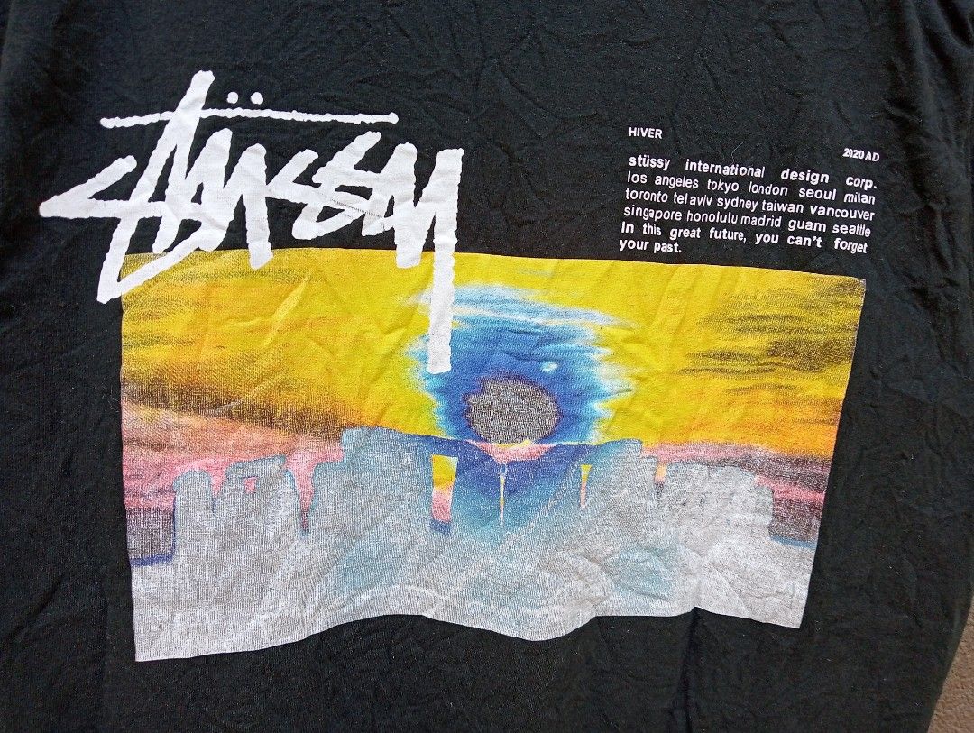 Authentic Stussy StoneHenge 2020 AD Graphic Tee Black Medium (Category: Tshirts & Polo Shirts ) located in Manila. Submitted by trifted.lootsph (Listing ID 1465398078, Image 3). Description: authentic StoneHenge Black Stussy graphic tee from the Hiver 2020 AD collection. Features colorful artwork on the front chest and a larger landscape graphic with branding text on the back. Short sleeves, classic crew neck. Tagged size medium, made in Mexico. 