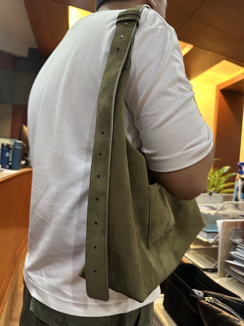 AZTRID olive green suede shoulder bag with adjustable strap (Category: Shoulder Bags) located in Manila. Submitted by fabkikay01 (Listing ID 1465430055, Image 2). Description: - Brand: ASTRID - Color: Olive Green - Material: Soft suede texture throughout - Closure: Secure top zip closure - Compartments: Spacious main compartment with an extra interior zippered pocket - Exterior: Front pocket featuring a small metallic brand logo plate - Strap: Ad