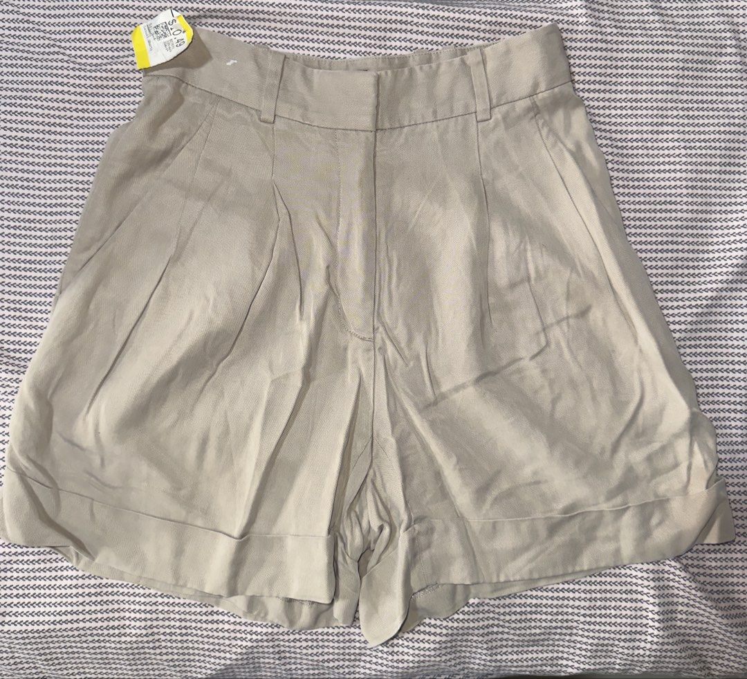 Babaton Talula Four Pleated Beige Shorts Size 4 (Category: Shorts) located in Santa Ana. Submitted by fatikilla (Listing ID 1465439039, Image 1). Description: - Brand/Style: Talula Babaton tailored shorts - Color: Versatile neutral beige - Size: 4 - Design: Pleated front with cuffed hems - Details: Zip fly, waistband with belt loops, and back welt pockets with button closures - Condition: Excellent.