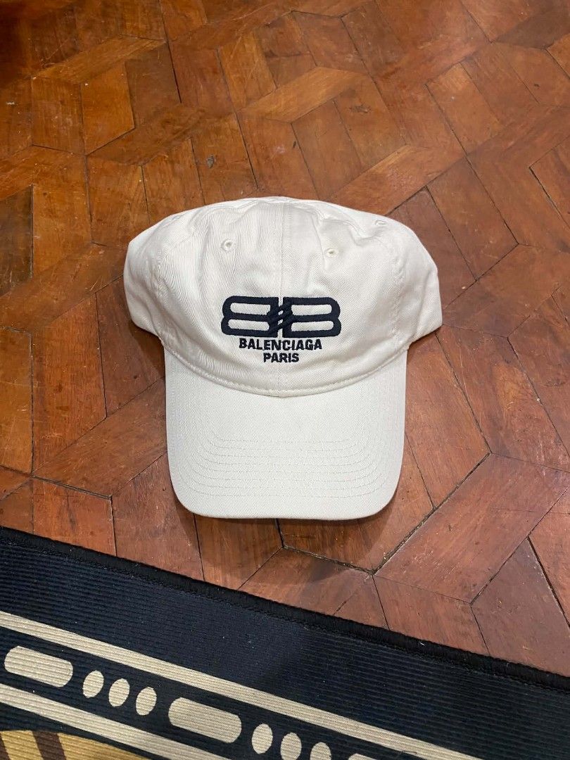 Balenciaga BB Paris Embroidered Baseball Cap White (Category: Caps & Hats) located in Pasig City. Submitted by paulclzdo (Listing ID 1465455837, Image 1). Description: - Brand: Balenciaga - Color: Crisp White - Material: 100% Cotton - Design: Embroidered BB logo on the front with 'Paris' lettering - Fit: Adjustable strap in the back for a custom fit - Style: Classic curved brim, clean look that pairs easily with casual everyday outfits.