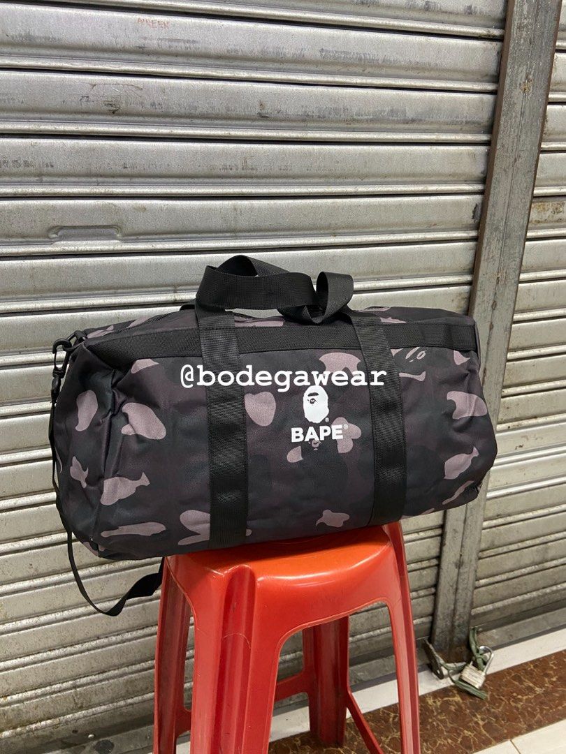 BAPE Camo Duffle Bag Green and Black (Category: Sling Bags) located in Manila. Submitted by bodegawear_mnl (Listing ID 1465407578, Image 2). Description: - Available Colors: Green Camo and Black Camo - Material: Durable, high-quality canvas with sturdy black carrying handles - Features: Bold BAPE logo patches on the front and a detachable shoulder strap (included with the black bag) - Versatility: Perfect size for the gym, travel, or everyday use