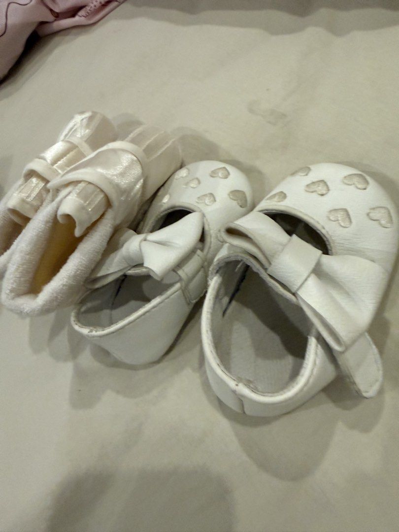 Baptism Baby White Shoes (Category: Babies & Kids Fashion) located in Paranaque City. Submitted by ammmt (Listing ID 1465413353, Image 1). Description: - Bundle of 2 pairs of cute white baby shoes - Pair 1: Features embroidered white hearts on the toe and a large matching front bow - Pair 2: Soft fabric booties with a secure strap and Pitter Pat brand tag inside - Designed specially for tiny infant feet - Great and versatile addition to any baby 