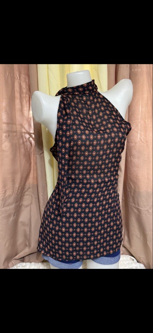 Black and Brown Patterned Halter Neck Sleeveless Blouse (Category: Sleeveless) located in Marikina City. Submitted by lorradel (Listing ID 1465394287, Image 2). Description: Black halter neck sleeveless blouse with brown and white geometric diamond pattern all over. High neck collar design with a hanging side ribbon accent. Lightweight fabric, pairs well with denim shorts or skirts. Simple pullover style. - might have washable stain due to storag