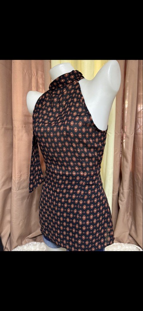 Black and Brown Patterned Halter Neck Sleeveless Blouse (Category: Sleeveless) located in Marikina City. Submitted by lorradel (Listing ID 1465394287, Image 3). Description: Black halter neck sleeveless blouse with brown and white geometric diamond pattern all over. High neck collar design with a hanging side ribbon accent. Lightweight fabric, pairs well with denim shorts or skirts. Simple pullover style. - might have washable stain due to storag