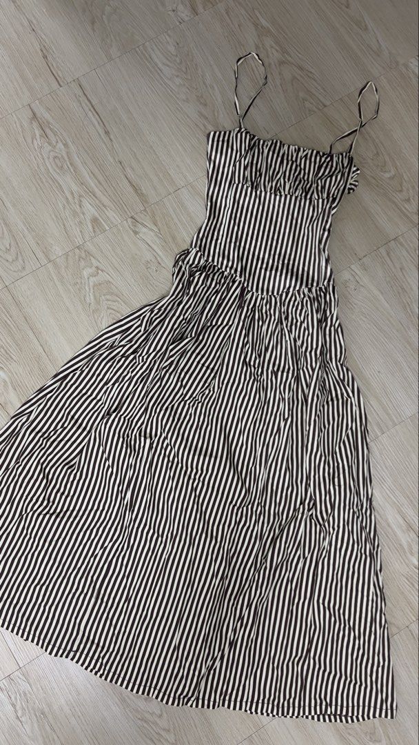 Brown striped midi dress (Category: Dresses) located in Marikina City. Submitted by clutters.of.a (Listing ID 1465577802, Image 3). Description: - Color/Pattern: Classic black and white stripes - Length: Midi (hits around mid-calf) - Design: Square neckline, ruched bodice detail, and flared skirt - Straps: Thin straps - Fabric: Lightweight and breathable for warm weather - Condition: Excellent, no flaws noticed - Style: Easy to throw on for casua