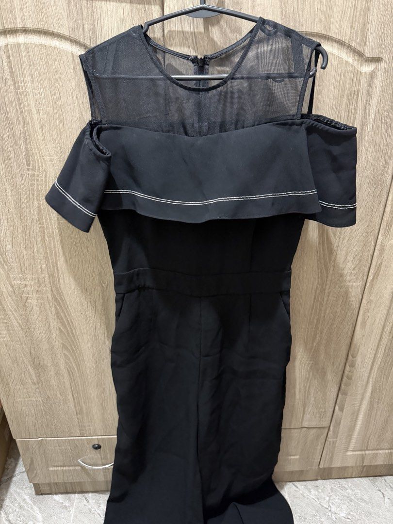 Black Cold Shoulder Ruffle Jumpsuit with Mesh Top (Category: Jumpsuits) located in Calamba. Submitted by nicalison (Listing ID 1465456803, Image 1). Description: - Color: Sleek Black with contrast white stitching - Design: Sheer mesh top, cold shoulder cutouts, and layered chest ruffle - Fit: Fitted waistline with a straight-leg cut and white trim cuffs - Closure: Convenient back neck zipper - Occasion: Versatile minimalist piece for dinner dates